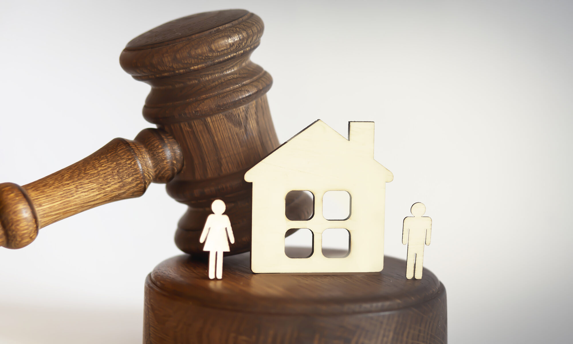 Divorce concept with gavel and wooden house and figure on white background