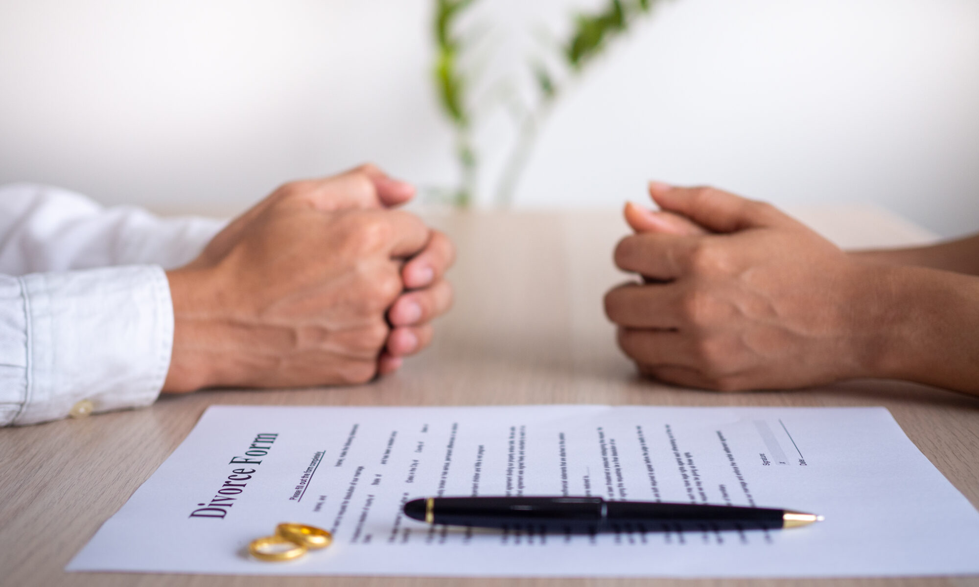The hands of the wife and husband with the order of divorce, dissolution, cancellation of marriage, legal separation documents, divorce filings or pre-marital agreements prepared by a lawyer.